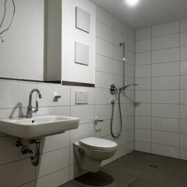 Badezimmer mit bodengleicher Dusche, WC, Waschbecken