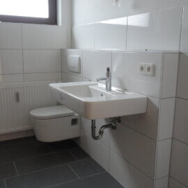 Modernes Bad mit Dusche, WC, Waschbecken, Waschmaschinenanschluss