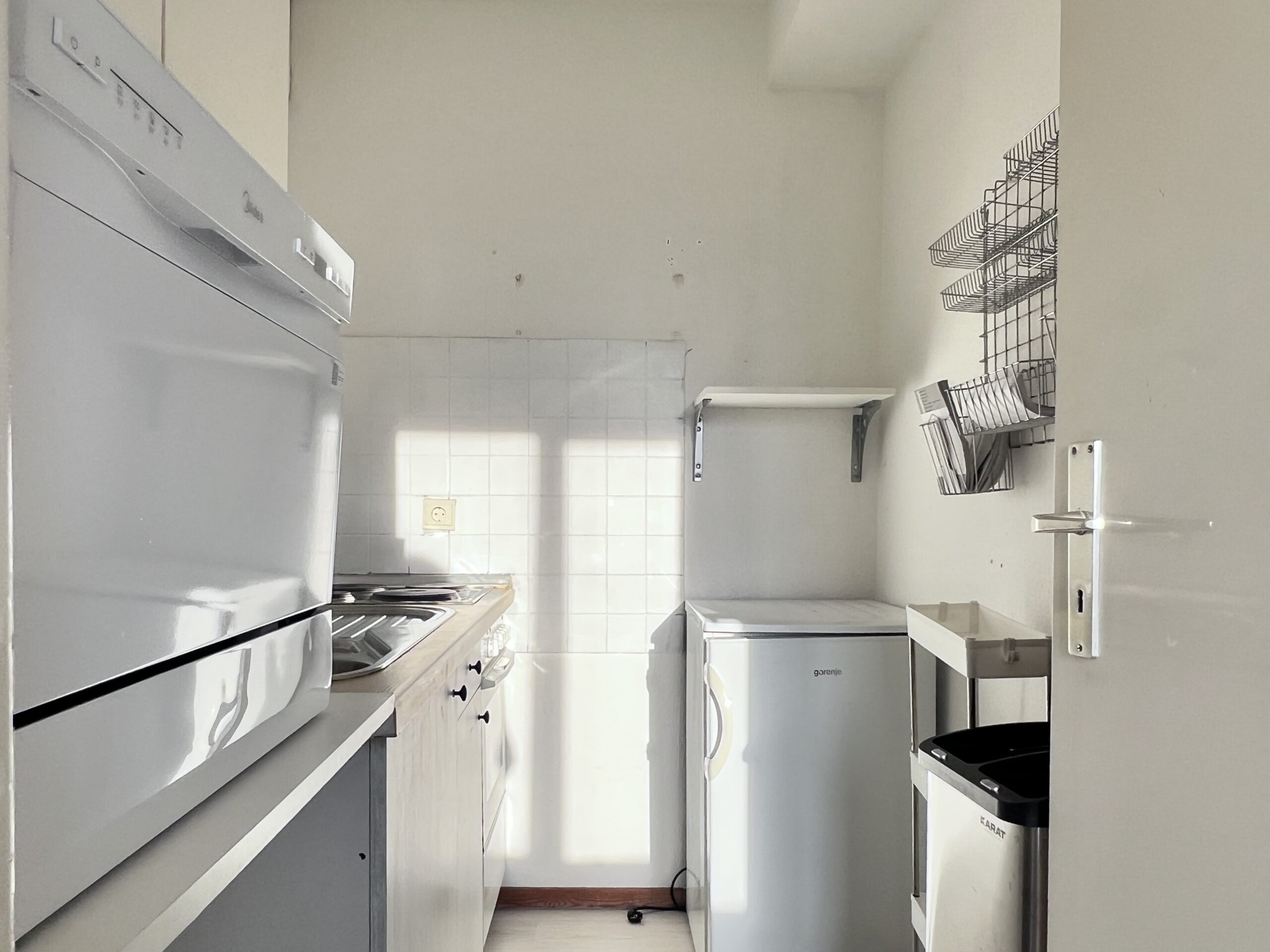 Kleine Küche mit Kühlschrank, Herd, Spüle, kleinem Geschirrspüler